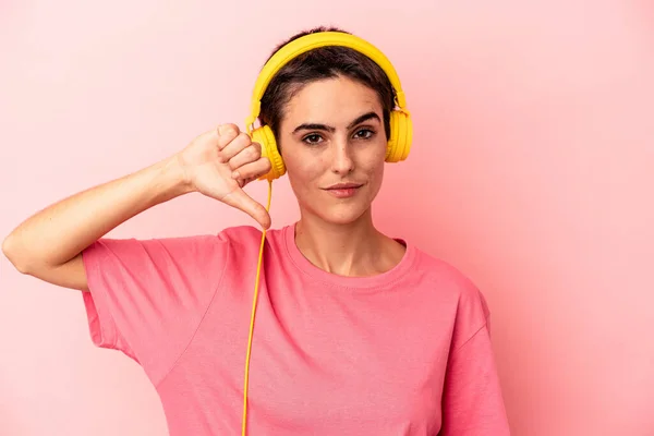 Young Caucasian Woman Listening Music Isolated Pink Background Showing Dislike — Stock Photo, Image