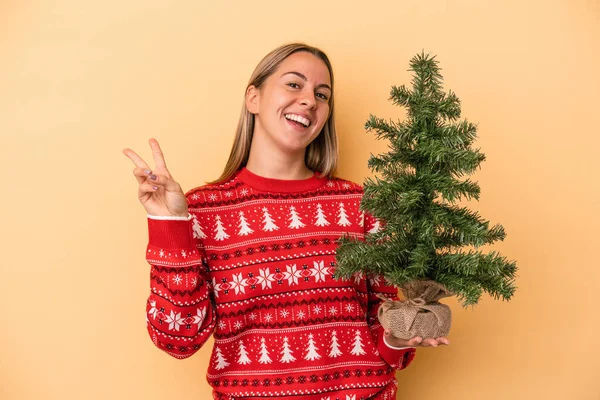 Jovem Caucasiana Segurando Uma Pequena Árvore Natal Isolada Fundo Amarelo — Fotografia de Stock