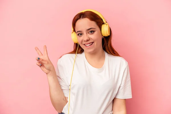 Joven Mujer Caucásica Escuchando Música Aislada Sobre Fondo Rosa Alegre —  Fotos de Stock