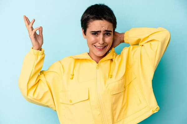 Young caucasian woman isolated on blue background screaming with rage.