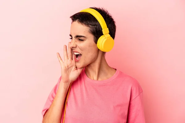 Young Caucasian Woman Listening Music Isolated Pink Background Shouting Holding — Φωτογραφία Αρχείου