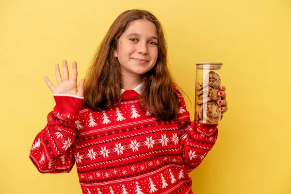 Kis Kaukázusi Lány Kezében Egy Karácsonyi Süti Elszigetelt Sárga Háttér — Stock Fotó