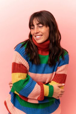 Arjantinli genç bir kadın pembe arka planda izole edilmiş.