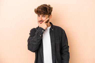 Genç Arap adam bej arka planda izole edilmiş. Bir strateji planlıyor, bir iş yolu düşünüyor..