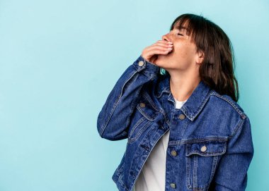 Arjantinli genç bir kadın mavi arka planda izole edilmiş gülerek, kaygısız, doğal duygular içinde..