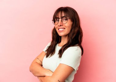 Pembe arka planda izole edilmiş genç Arjantinli kadın mutlu, güler yüzlü ve neşeli.