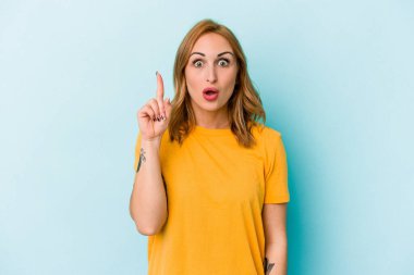 Mavi arka planda izole edilmiş beyaz bir kadın ağzı açık bir şekilde üst tarafı işaret ediyor..
