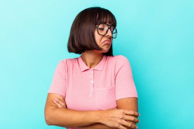 Mavi arka planda izole edilmiş genç melez kadın tekrarlanan bir görevden yoruldu..