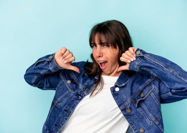 Mavi arka planda izole edilmiş genç Arjantinli kadın gururlu ve kendinden emin hissediyor, örnek olarak.