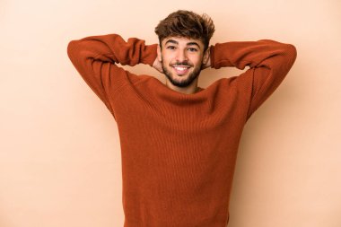 Young arab man isolated on beige background stretching arms, relaxed position.