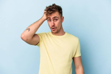 Mavi arka planda izole genç beyaz adam şok oldu, o önemli bir toplantı hatırladı.