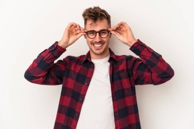 Beyaz arka planda izole edilmiş genç beyaz bir adam gözlerinde sorun olmadığını gösteriyor.