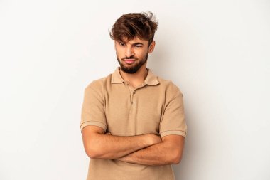 Genç melez adam gri arka planda izole edilmiş. Kameraya alaycı bir ifadeyle bakıyor..