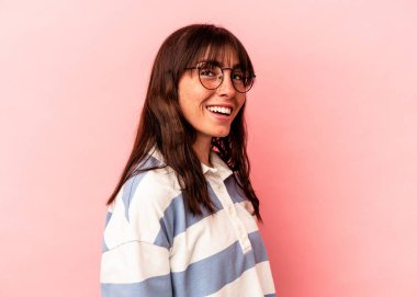 Arjantinli genç bir kadın pembe arka planda izole edilmiş..