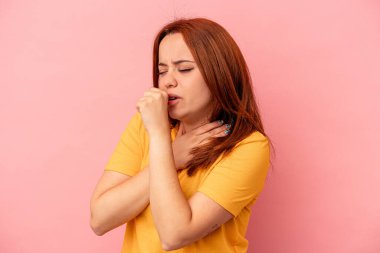 Pembe arka planda izole edilmiş genç beyaz kadın virüs veya enfeksiyon yüzünden boğazında ağrı hissediyor..