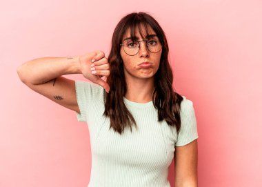 Pembe arka planda izole edilmiş genç Arjantinli kadın hoşlanmadığı bir jest gösteriyor. Anlaşmazlık konsepti.