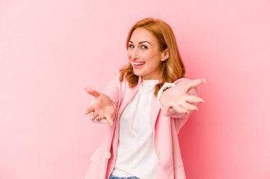 Pembe arka planda izole edilmiş genç beyaz kadın kameraya sarıldığı için kendinden emin..