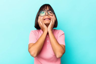 Genç melez kadın, mavi arka planda yalnız başına sızlanıyor ve ağlıyordu..