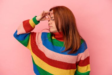 Pembe arka planda soyutlanmış, başı ağrıyan, yüzüne dokunan beyaz bir kadın..