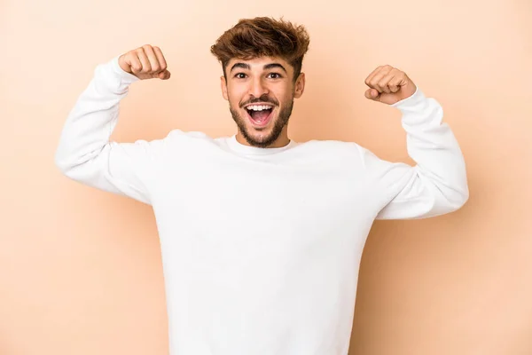 Young Arab Man Isolated Beige Background Showing Strength Gesture Arms — стоковое фото