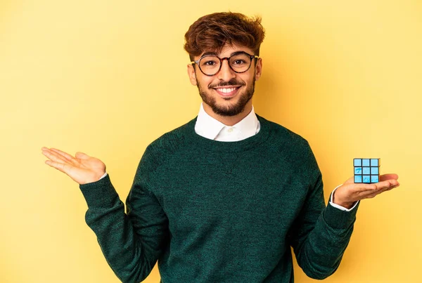 Young Mixed Race Man Holding Rubiks Cube Isolated Yellow Background — Stock fotografie