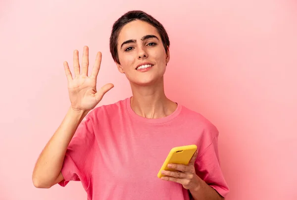 Ung Kaukasiska Kvinna Som Håller Mobiltelefon Isolerad Rosa Bakgrund Ler — Stockfoto