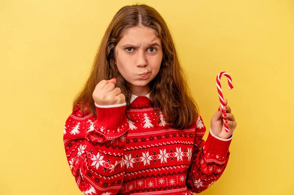 배경에 고립된 크리스마스 스틱을 코카서스 소녀가 카메라에 주먹을 보이며 공격적 — 스톡 사진