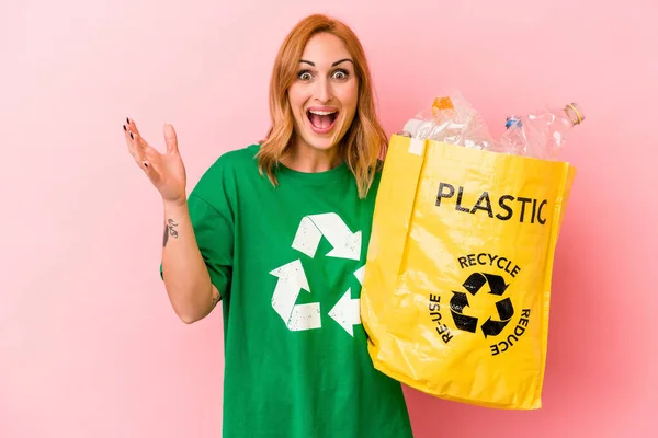 Young Caucasian Woman Recycled Plastic Isolated Pink Background Receiving Pleasant — Stok fotoğraf