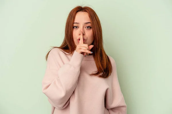 Young Caucasian Woman Isolated Green Background Keeping Secret Asking Silence — Stock Photo, Image
