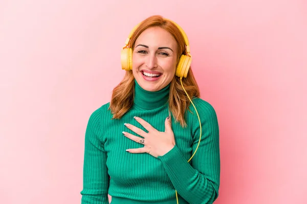 Young Caucasian Woman Listening Music Isolated Pink Background Laughs Out — Φωτογραφία Αρχείου