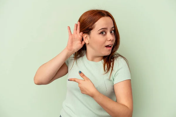 Giovane Donna Caucasica Isolata Sfondo Verde Cercando Ascoltare Pettegolezzo — Foto Stock