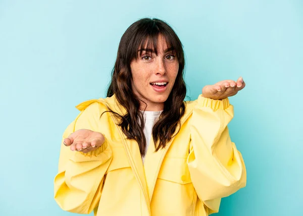 Young Argentinian Woman Isolated Blue Background Makes Scale Arms Feels — Stock Photo, Image
