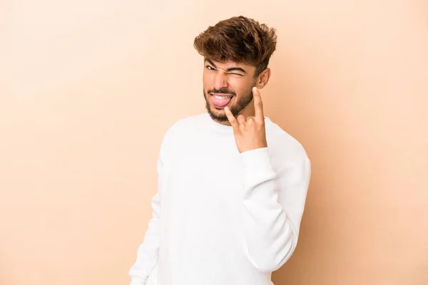 Young Arab Man Isolated Beige Background Showing Rock Gesture Fingers — стоковое фото