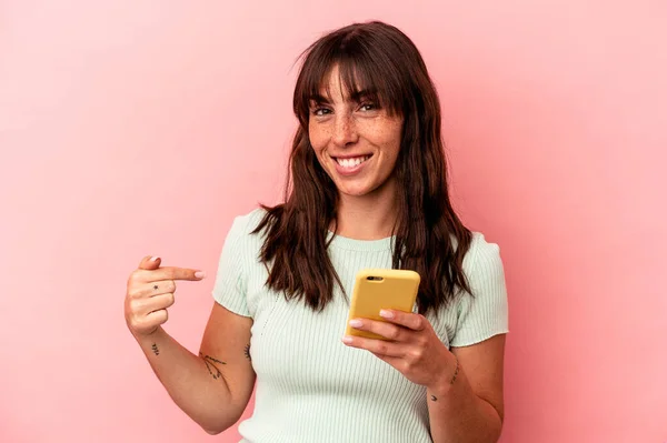 Joven Argentina Sosteniendo Teléfono Móvil Aislado Sobre Fondo Rosa Apuntando —  Fotos de Stock