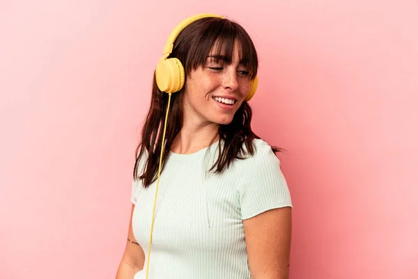 Young Argentinian Woman Listening Music Isolated Pink Background Looks Aside — Stock Photo, Image