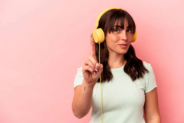 Young Argentinian Woman Listening Music Isolated Pink Background Showing Number — Stock Photo, Image