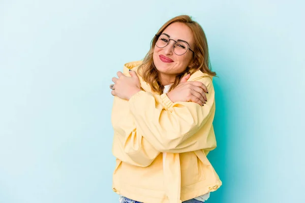 Mulher Caucasiana Jovem Isolado Abraços Fundo Azul Sorrindo Despreocupado Feliz — Fotografia de Stock