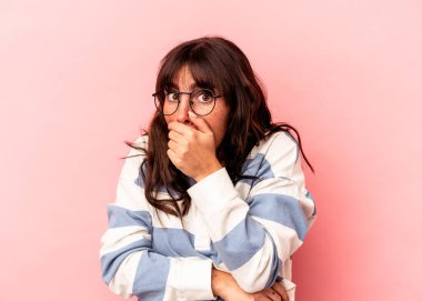 Genç Arjantinli kadın pembe arka planda izole edilmiş korkmuş ve korkmuş..