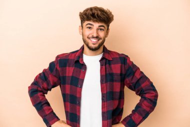 Young arab man isolated on beige background happy, smiling and cheerful.
