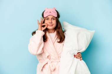 Küçük beyaz kız mavi arka planda izole bir şekilde uyuyacak. Parmakları dudaklarında bir sır saklıyor..