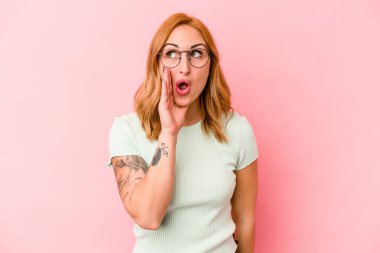 Pembe arka planda izole edilmiş beyaz bir kadın heyecanlı bir şekilde bağırıyor..