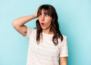 Arjantinli genç bir kadın mavi arka planda izole edilmiş şoka uğrayan, önemli bir toplantıyı hatırladı..