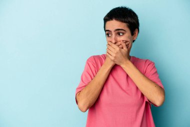 Kafkasyalı genç bir kadın mavi arka planda izole edilmiş düşünceli bir şekilde ağzıyla ağzını kapatan bir fotokopi odasına bakıyor..