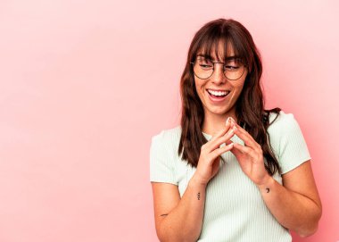 Arjantinli genç bir kadın pembe arka planda izole edilmiş bir plan kuruyor..