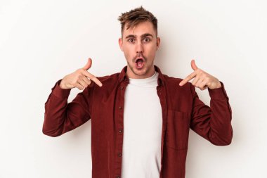 Beyaz arka planda izole edilmiş genç beyaz bir adam parmakları aşağıda, olumlu bir his var..