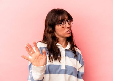 Pembe arka planda izole edilmiş genç Arjantinli bir kadın tiksinti belirtisi gösteren birini reddediyor..