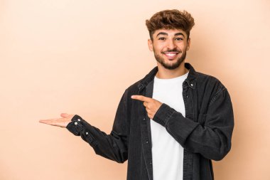 Genç Arap, bej arka planda izole edilmiş..