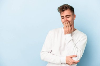 Kafkasyalı genç adam mavi arka planda yalnızdı gülerek, kaygısızca, doğal duygularla.