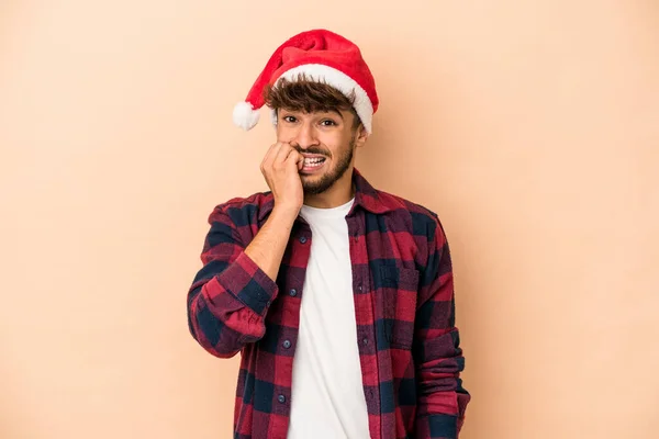 Young Arab Man Celebrating Christmas Isolated Beige Background Biting Fingernails — Stockfoto
