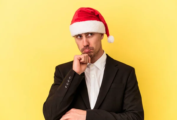 若いですCaucasian男祝い新年身に着けていますクリスマス帽子孤立した上の黄色の背景 — ストック写真
